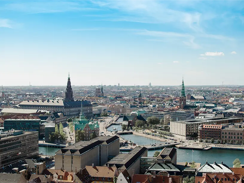 Udsigt over Københavns tage med Christiansborg og kanalen i centrum.