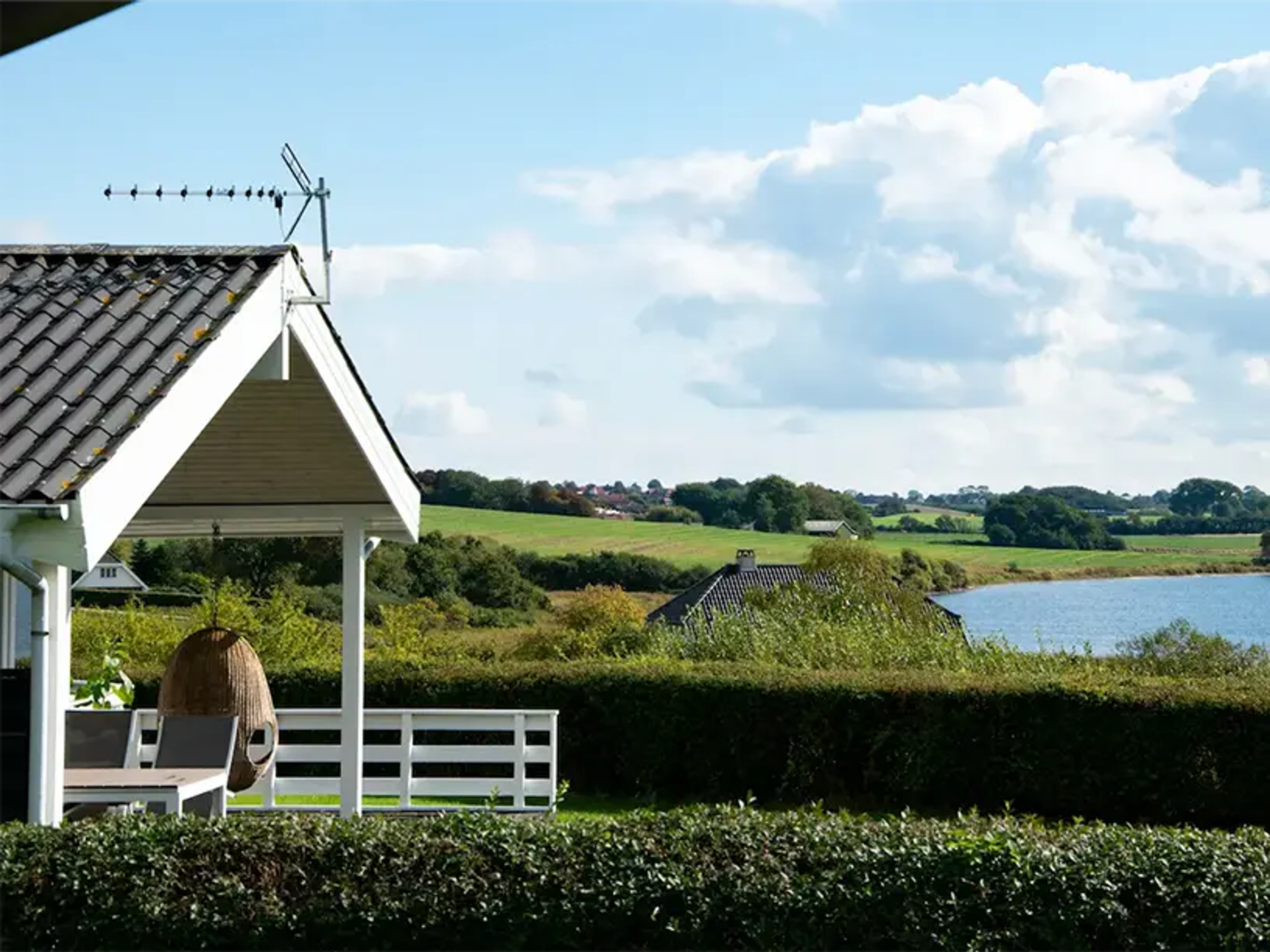 Et sommerhus med grønt tag.