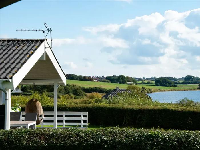 Et sommerhus med grønt tag.