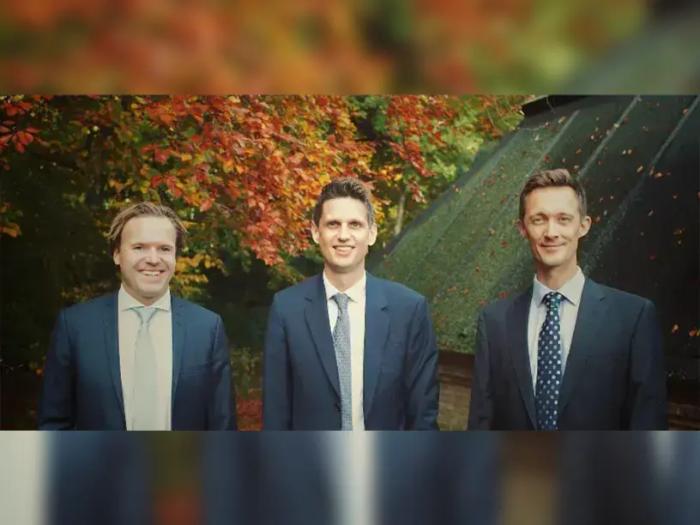 Tre mænd i jakkesæt diskuterer finansieringsmuligheder for et byggeprojekt.
