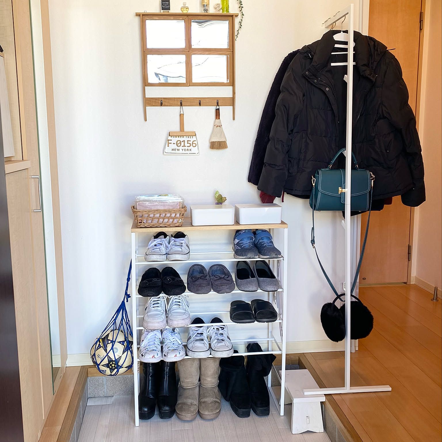 A bright Japanese entryway using a slim shoe rack top and coat hanger as a compact daily landing zone.