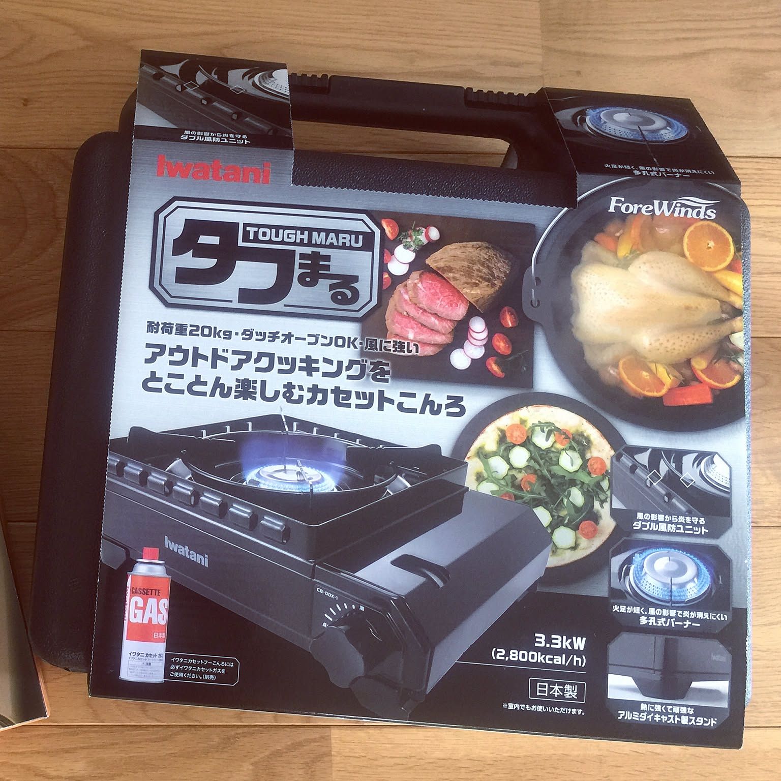 An unlit Iwatani portable cassette stove packed in its carrying case for outdoor emergency cooking.