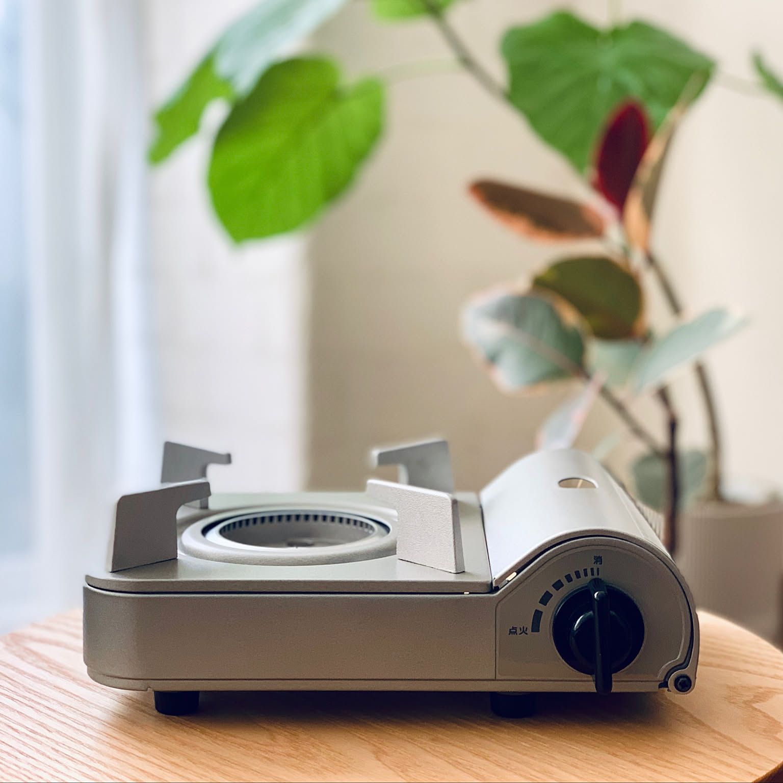 An Iwatani Eco Premium cassette stove shown clearly on a small wood table.