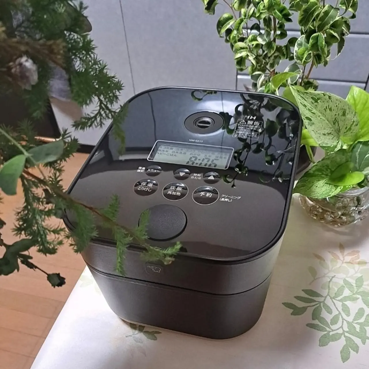 A black Zojirushi STAN. 5.5-cup rice cooker shown close-up as the main subject.