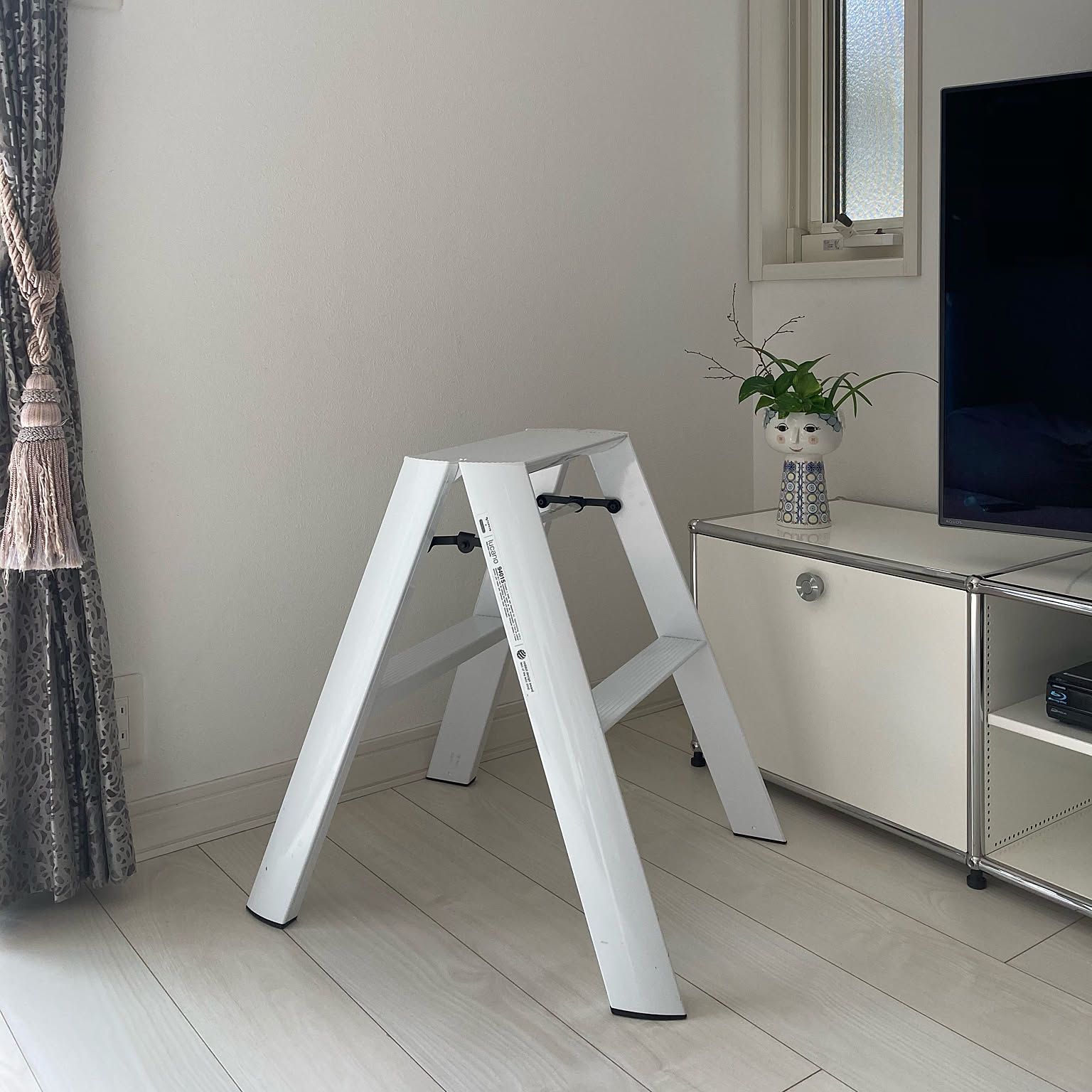 White lucano 2-step stool standing open in a living room