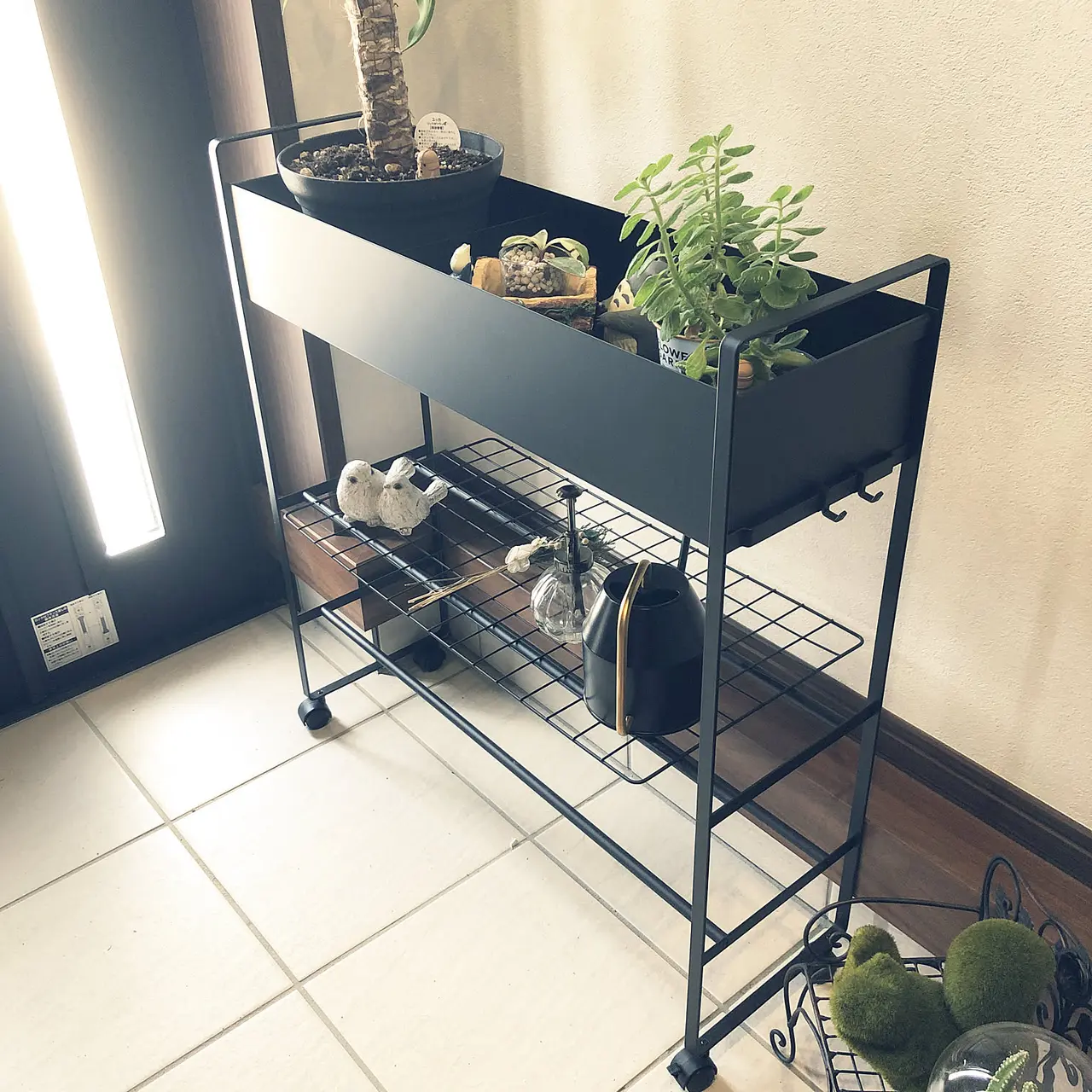A slim rolling entryway storage cart organizing everyday items in a small Japanese apartment entryway.