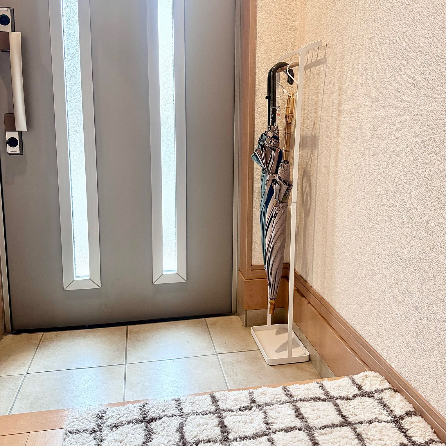 A slim white Yamazaki umbrella stand in a compact Japanese entryway.