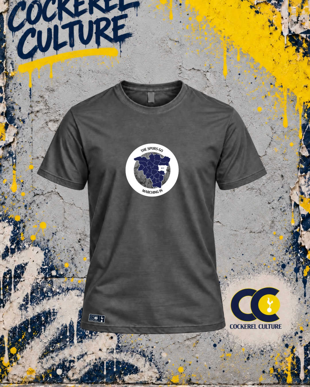 A dark grey t-shirt with a circular badge holding a map of the North London boroughs, with the words The Spurs Go Marching In set around the ring across the chest, seen from the front.