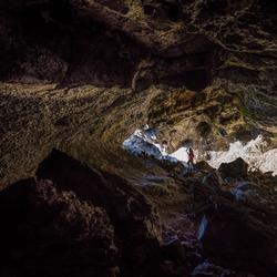 Person stands in the light at the end of a cave in Minnesota