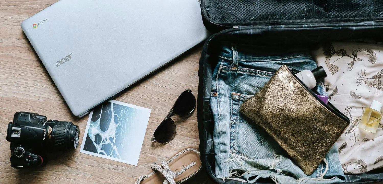 Packing up clothes, computer, camera, and sunglasses for an upcoming trip to visit a community.