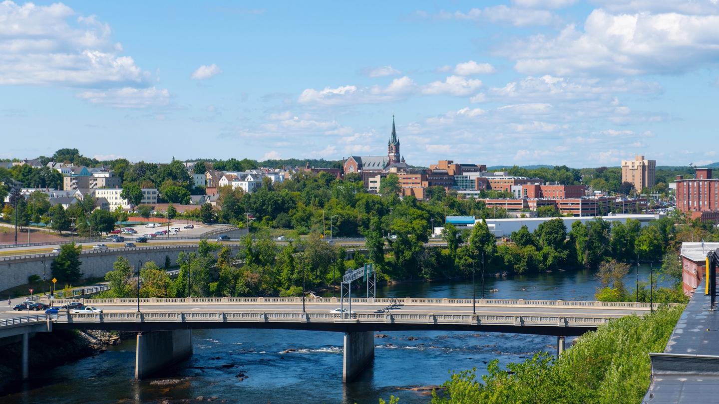 A view of the beautiful Manchester historic city skyline with sights including Merrimack River, Granite Street Bridge, and West Side Sainte Marie Parish church.