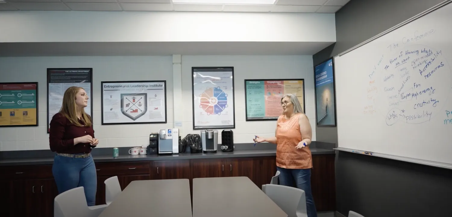 Two women having a brain-storming session in a conference room