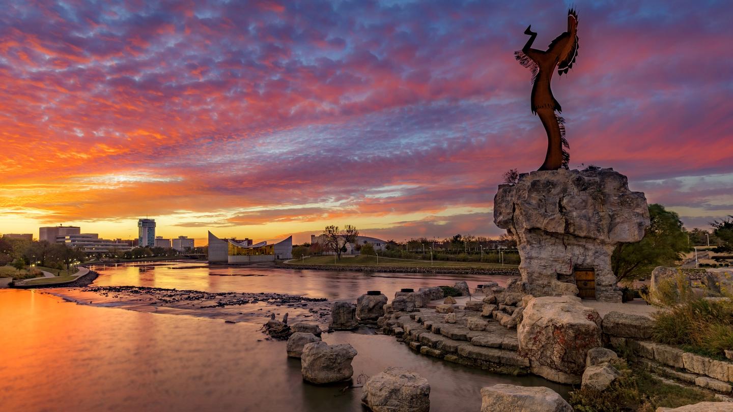 Stunning sunrise view of The Keeper of the Plains steel-sculpted statue overlooking the city. 