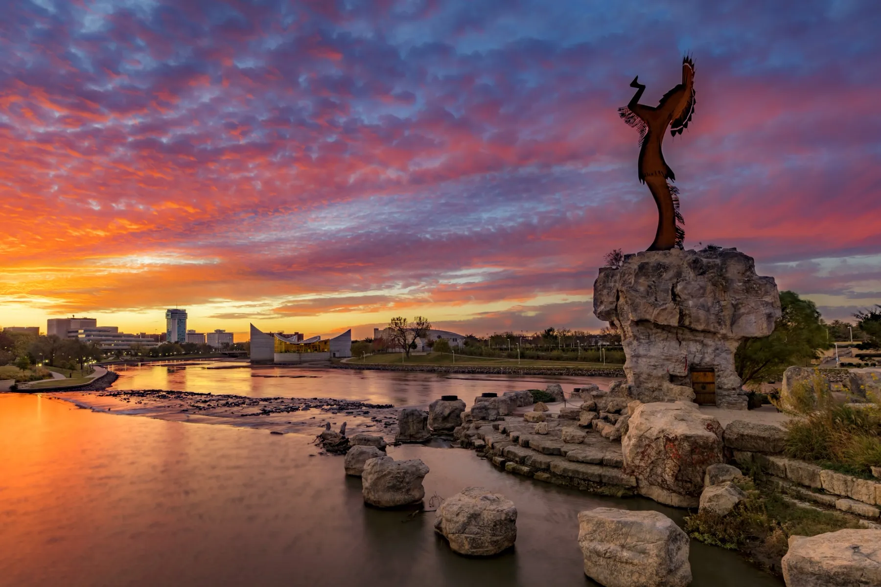 Stunning sunrise view of The Keeper of the Plains steel-sculpted statue overlooking the city.
