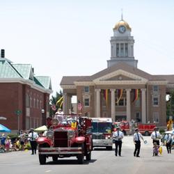 An old fire truck transporting people down the road during the Strassenfest Parade in Jasper, Indiana
