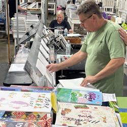 Employees at Bound to Stay Bound prepare materials for books to be custom bound in Jacksonville.