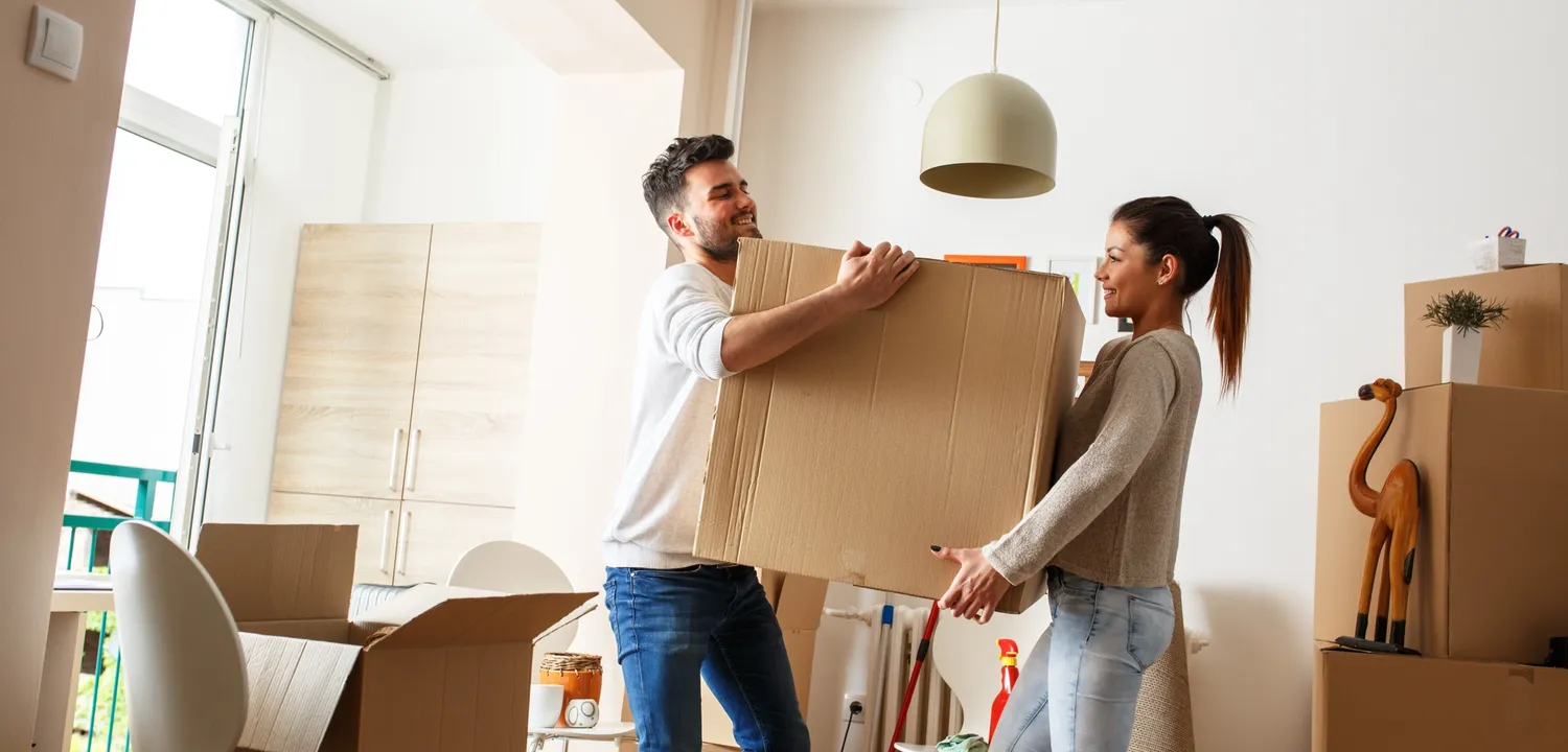 man and woman carrying a moving box