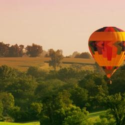 Hot air balloon rises over hills in Iowa