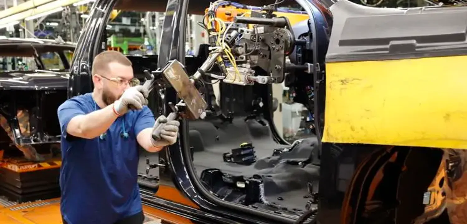General Motors employee working on a vehicle (Image Credit: The Journal Gazette)
