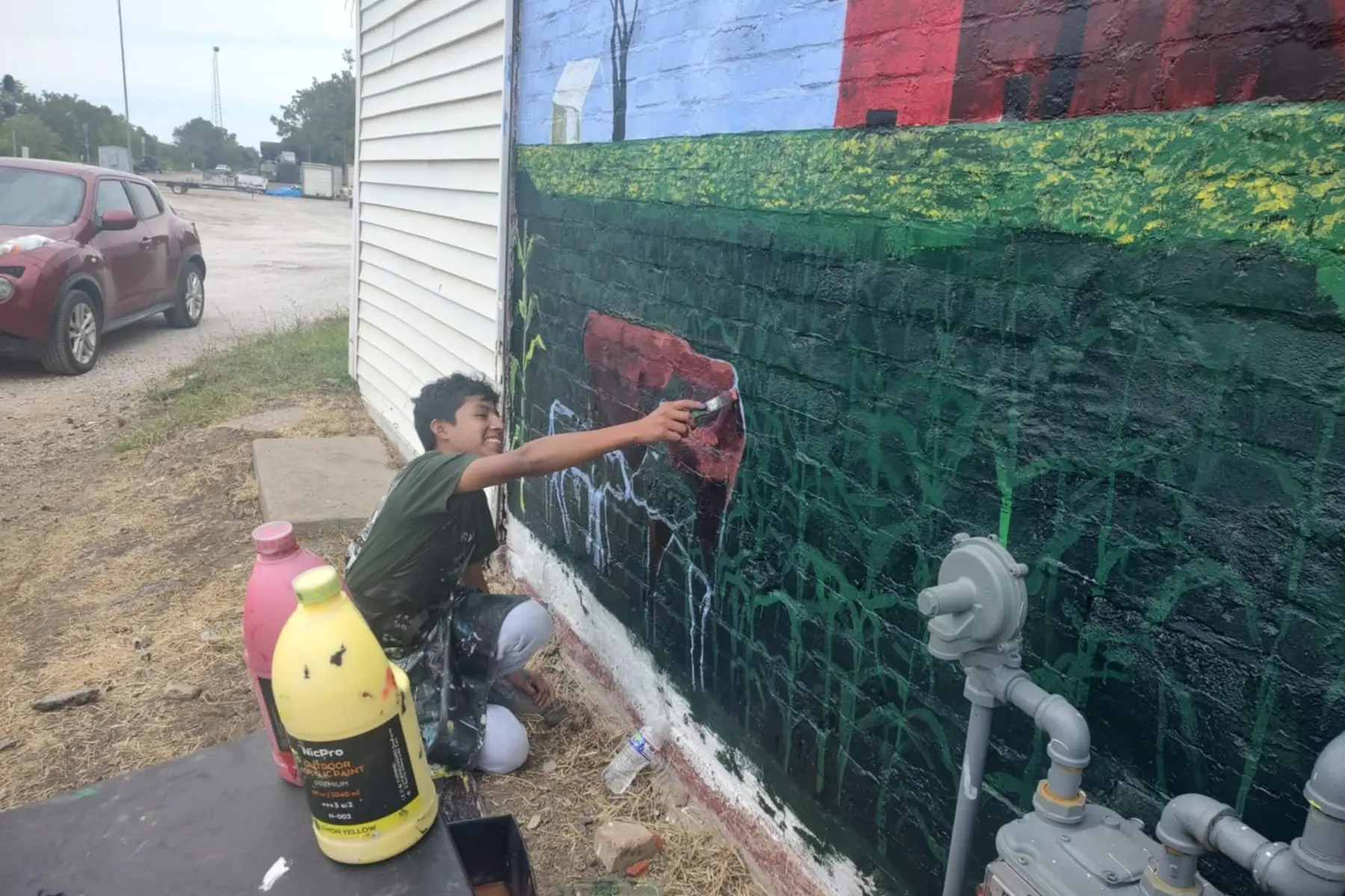 Local artist working on a community mural (Credit: MCAD)