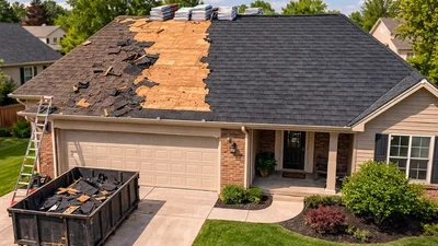 Residential roof replacement in progress showing exposed decking, new shingle bundles, and a dumpster filled with old roofing materials