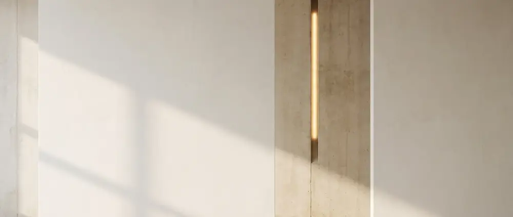 A bare plaster wall in raking daylight, a slim vertical recess lit warm gold