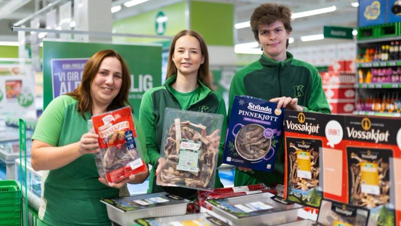 Tre KIWI-ansatte som viser frem et utvalg av pinnekjøtt i butikk.