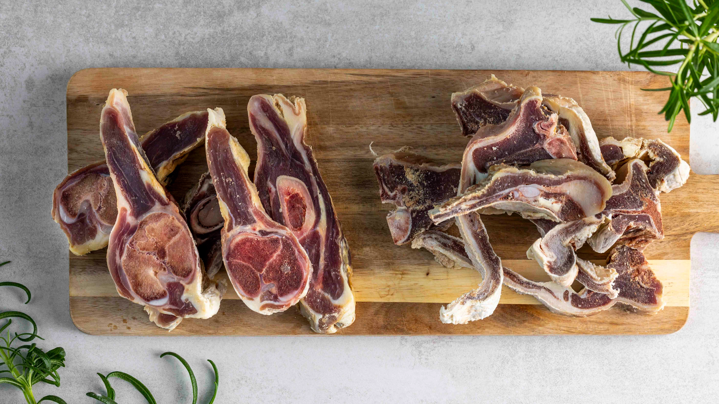 To ulike typer rå pinnekjøtt på trefjøl.