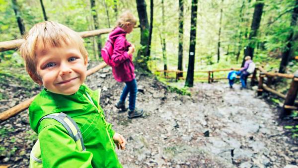 Barn og foreldre på tur i skogen.