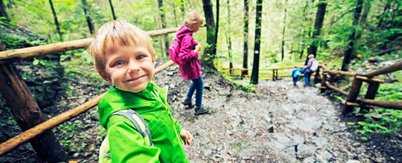 Barn og foreldre på tur i skogen.