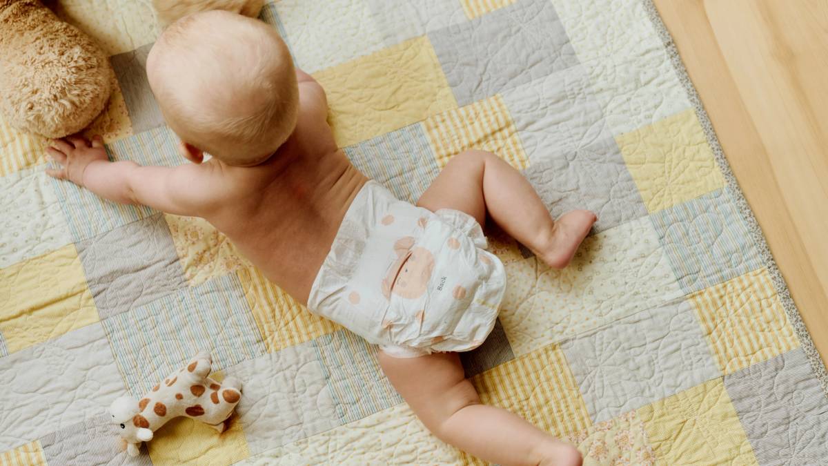 Baby på teppe med bleier fra Vilje.