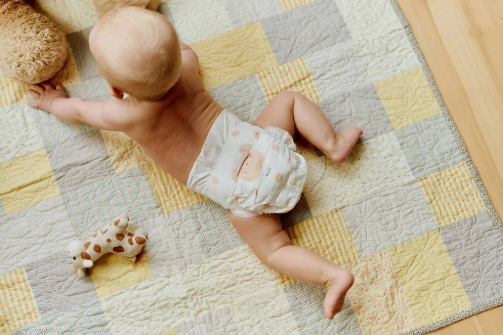 Baby på teppe med bleier fra Vilje.