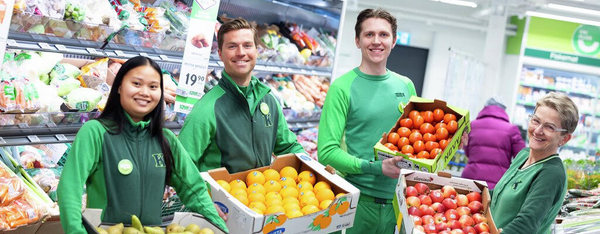 KIWI-ansatte som holder kasser med frukt og grønt.