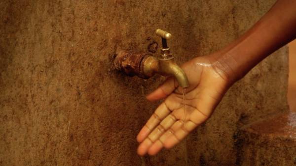 Hånd som holdes under vannkran.