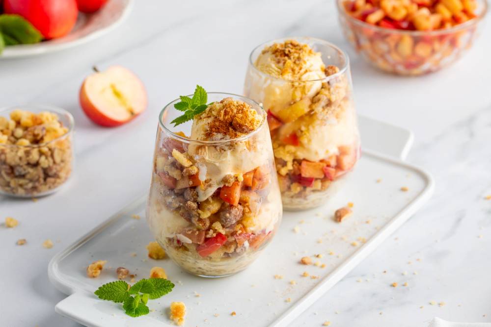 To dessertglass fylt med eplecrumble og vaniljeis fra Hennig Olsen Sørlandsis.