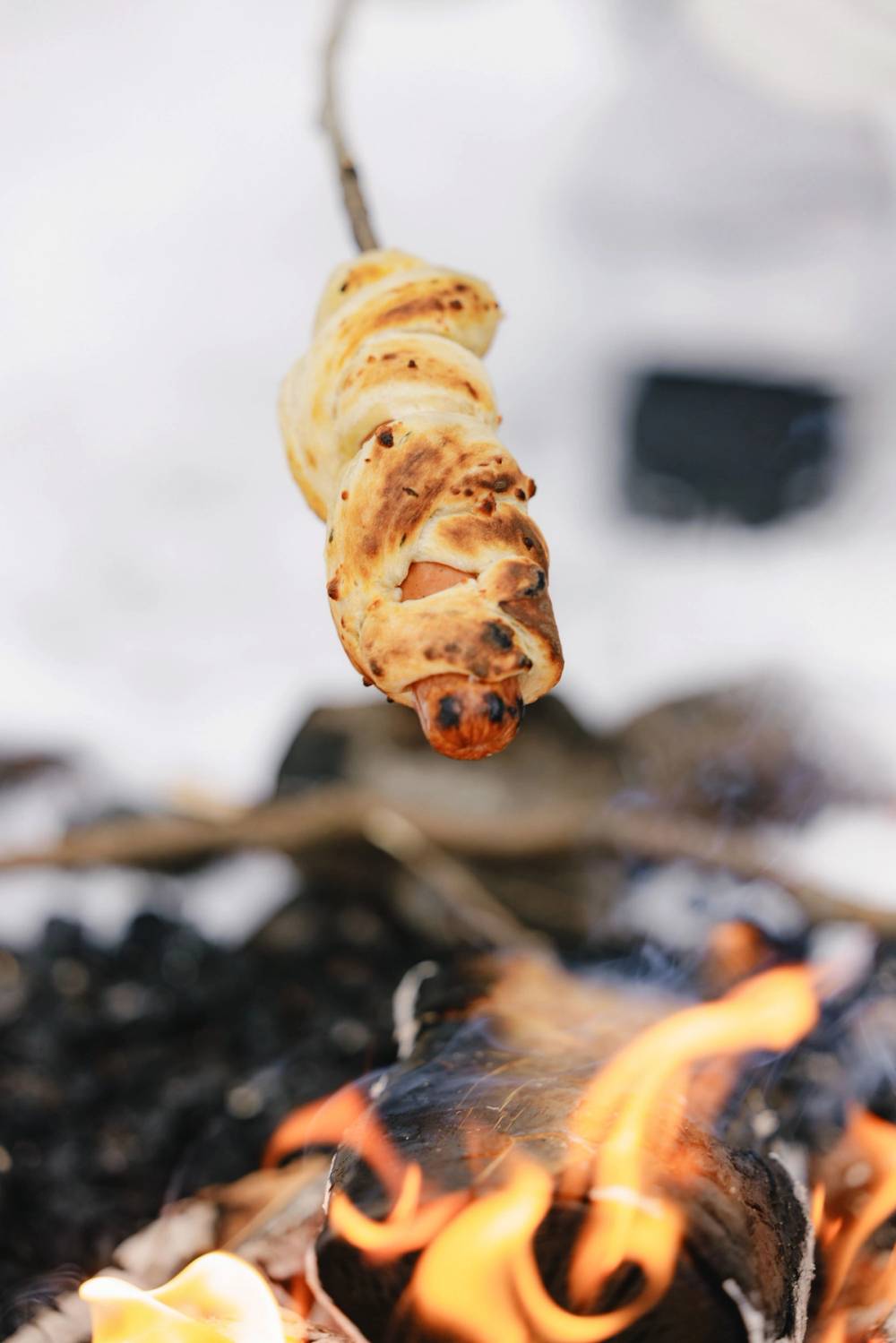 Pinnebrød med urter og ost som grilles over bål om vinteren.