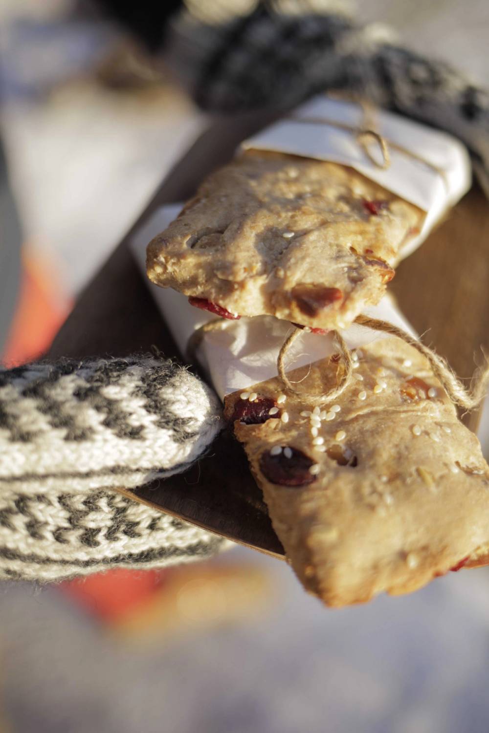 Hender med votter som holder en tallerken med müslibriks.