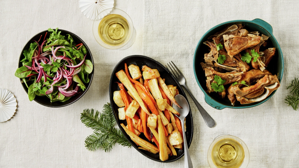 Pinnekjøtt med tilbehør som er satt frem på bord i kjele og på serveringsfat.