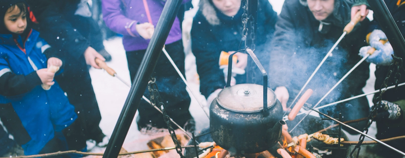 Barn og vokse rundt bål på hytta om vinteren.