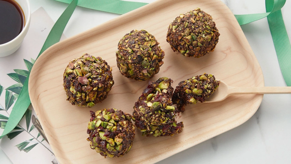 Seks daddelkuler som sunnere julesnacks på trefat.