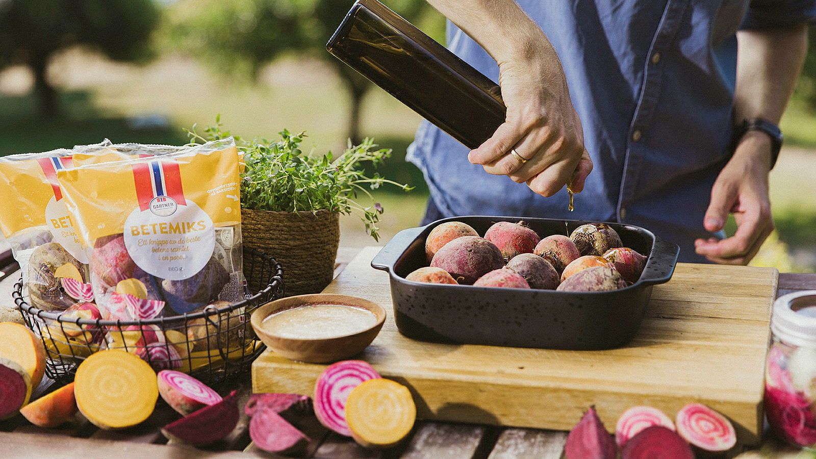 Person som heller olje på beter i ildfast form.