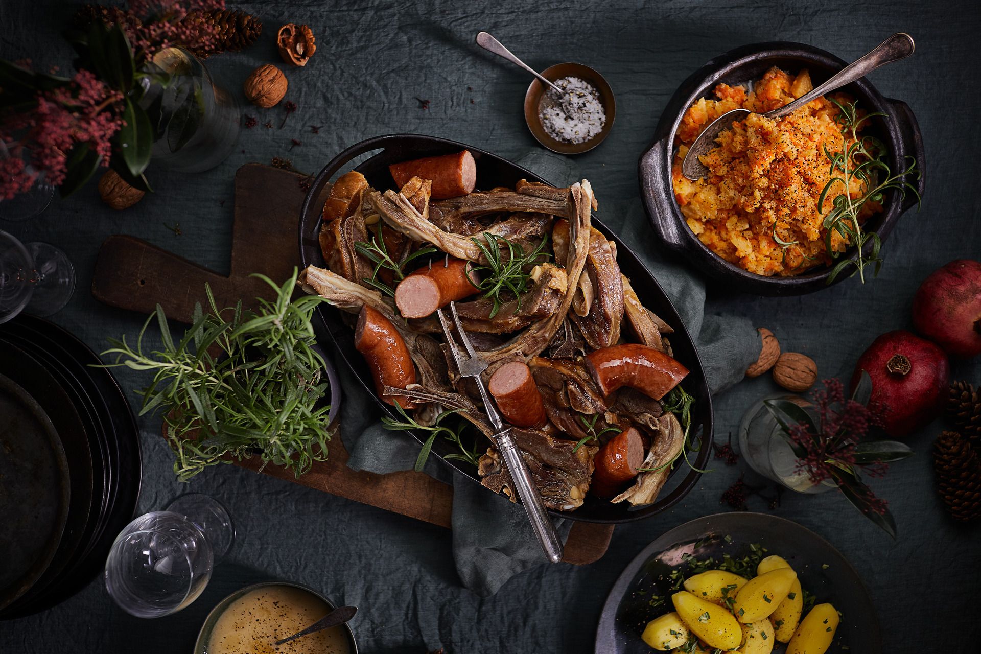 Bord dekket med fat med pinnekjøtt, vossakorv og kålrabistappe.