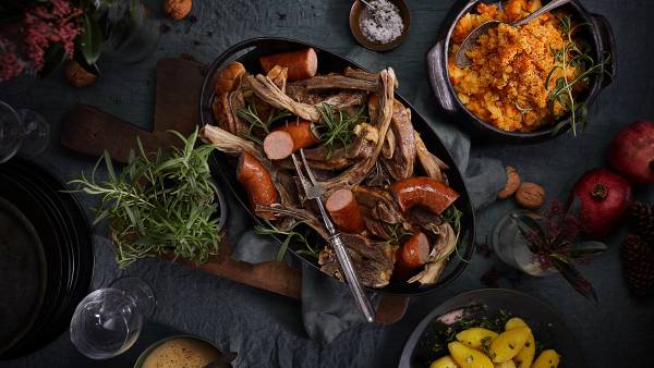 Bord dekket med fat med pinnekjøtt, vossakorv og kålrabistappe.