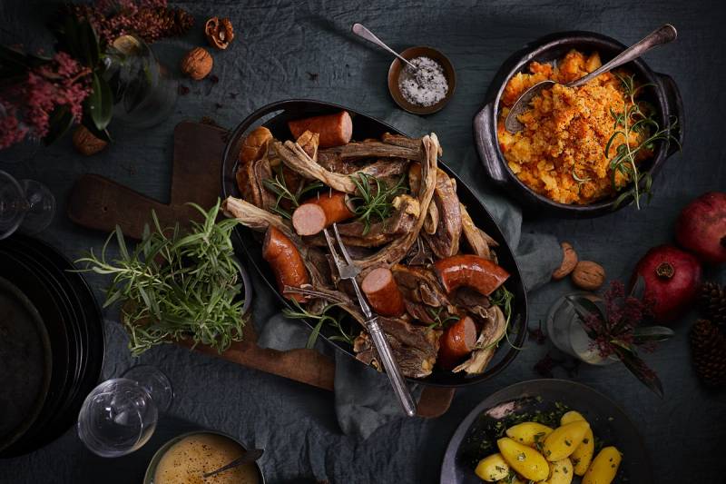 Bord dekket med fat med pinnekjøtt, vossakorv og kålrabistappe.