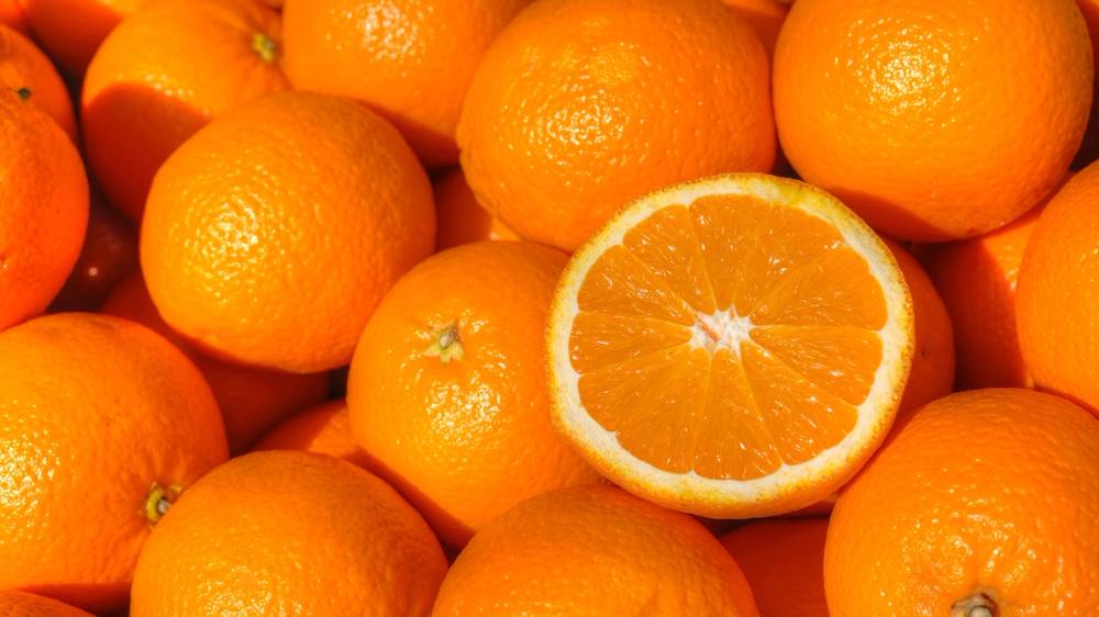 En huag med appelsiner og en halvside av en appelsin som er delt i to.