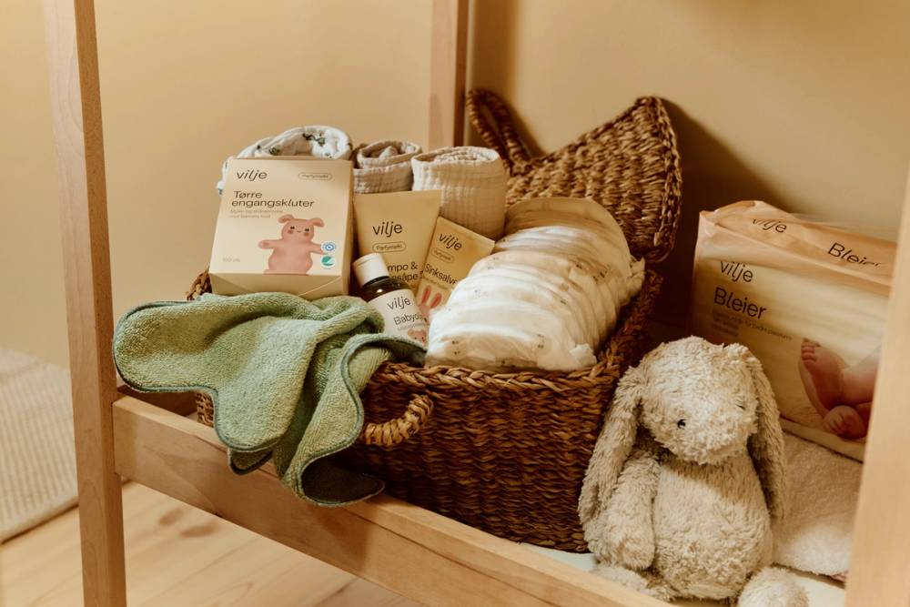 Hylle på stellebord med kurv med babyprodukter fra Vilje.