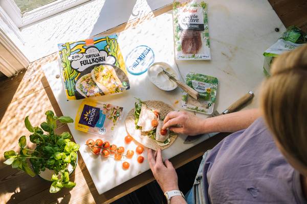 Kvinne som lager wraps med kyllingpålegg til matpakker til bilferie.
