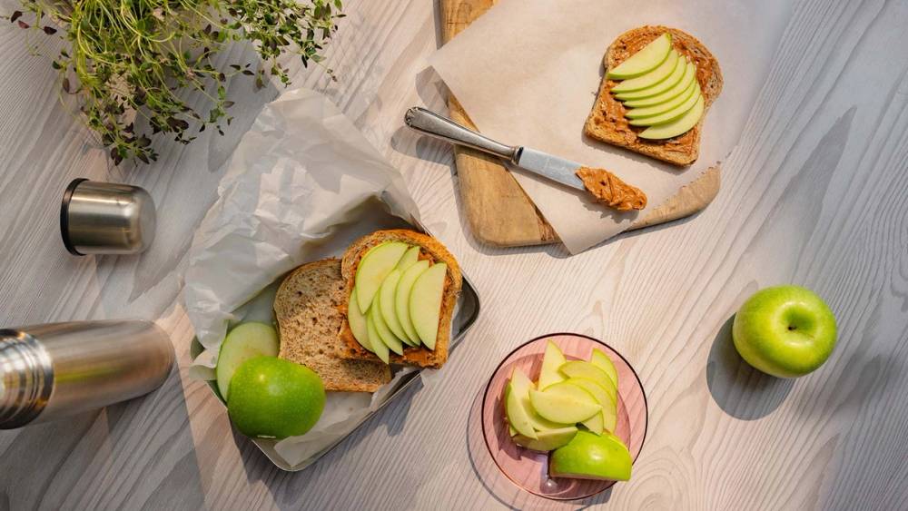 Matpakke med brødskiver med peanøttsmør og eple.