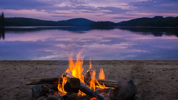 Bål ved vann i skogen.
