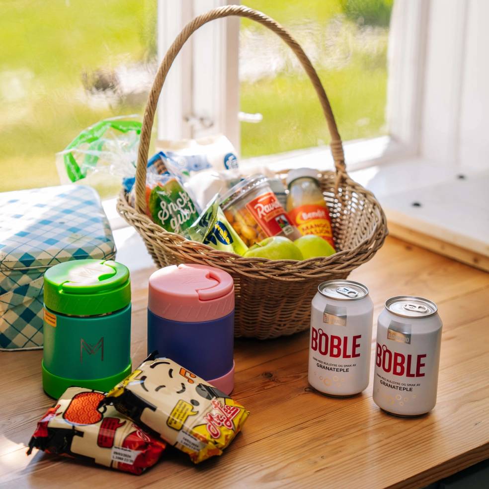 Kurv som er pakket med matvarer og drikkevarer på kjøkkenbenken før bilferie.